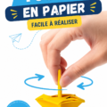 Dreidel en papier coloré posé sur une table en bois, décoré de dessins.
