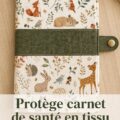 Protège carnet de santé en tissu coloré sur une table avec des fournitures de couture