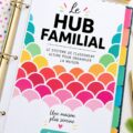 Un classeur de gestion familiale ouvert avec des onglets colorés et des notes.
